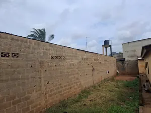 Vente d'un terrain à Agoè Kossigan, demi-lot clôturé bâti (5 pièces), ouvert sur rue de 14 m – 15 millions FCFA